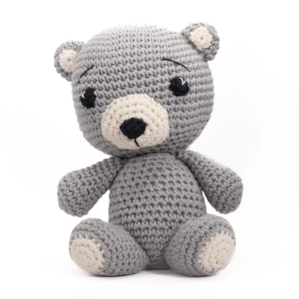 Håndlaget heklet bamse i grått og beige garn med mørke øyne – Balder Bjørn, en koselig hjertevenn med et mildt uttrykk.