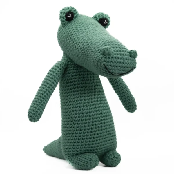 Heklet grønn kosedyr-alligator med smilende uttrykk, kjent som Arne Alligator – en håndlaget hjertevenn.