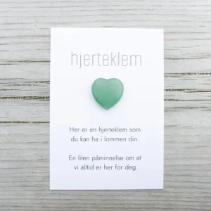 Grønn hjerteklem fra oss – et lite hjerte på kort med teksten «Her er en hjerteklem som du kan ha i lommen din. En liten påminnelse om at vi alltid er her for deg.»