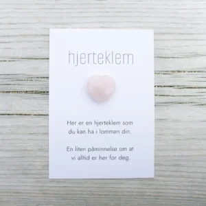 Rosa hjerteklem fra oss – et lite hjerte på kort med teksten «Her er en hjerteklem som du kan ha i lommen din. En liten påminnelse om at vi alltid er her for deg.»